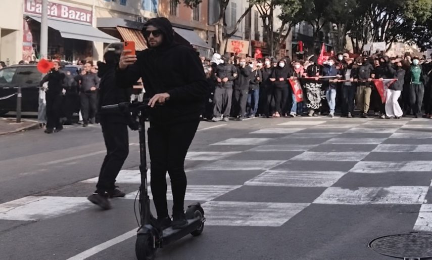 Párizsi tüntető telefonnal, rolleren